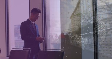 Asyalı iş adamının veri işleme ve şehir manzarası üzerinde akıllı telefon kullandığı görüntü. Küresel iş, finans, dijital arayüz, hesaplama ve veri işleme kavramı dijital olarak oluşturulmuş görüntü.