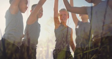 Güneşin ve çimenlerin, açık hava spor sınıfında el ele tutuşan mutlu okul çocukları üzerindeki görüntüsü. Okul, eğitim, sağlık, çocukluk ve öğrenme, dijital olarak oluşturulmuş görüntü.