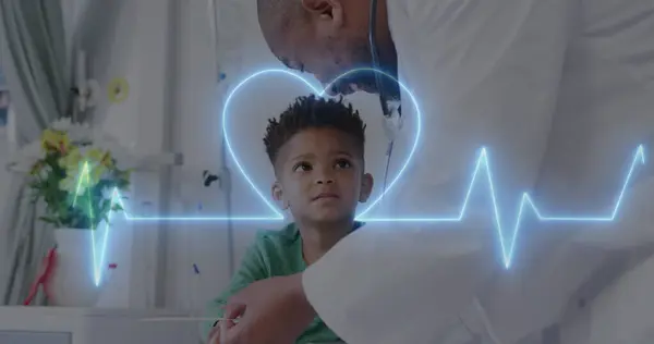 Image of heart monitor over african american male doctor with boy patient. Global medicine, healthcare, digital interface, computing and data processing concept digitally generated image.