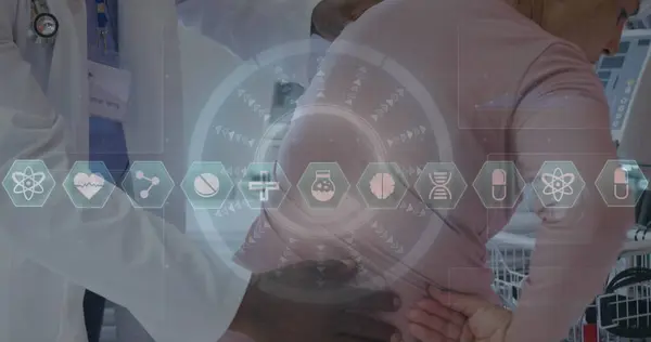 Image of icons and data over african american male doctor with female patient. Global medicine, healthcare, digital interface, computing and data processing concept digitally generated image.