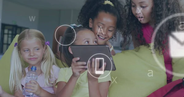 Image of media and data icons over happy diverse schoolgirls using tablet at break. School, education, communication, friendship, childhood and learning, digitally generated image.