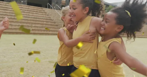 Obrázek Zlaté Konfety Nad Šťastnými Školačkami Které Slaví Objímají Sportovním — Stock fotografie