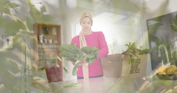 一个头戴头巾的女人 站在灯光下看着厨房的蔬菜 食品准备和家庭生活方式概念 — 图库视频影像