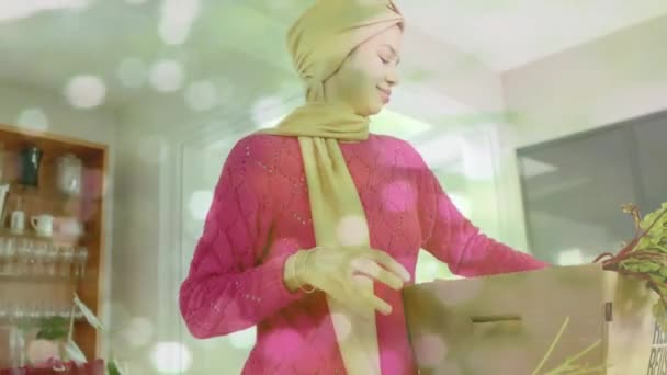 Biracial Kvinna Hijab Tar Grönsaker Lådan Köket Över Fläckar Ljus — Stockvideo