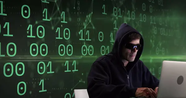 Image of caucasian male hacker over binary code on green background. global internet security, data processing, connections and digital interface concept digitally generated image.