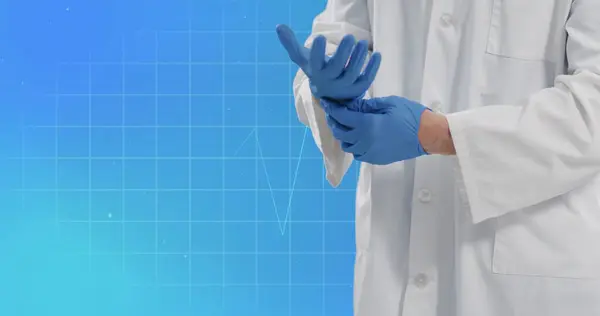 Image of cardiograph with caucasian doctor wearing medical gloves on blue background. Global medicine and digital interface concept digitally generated image.