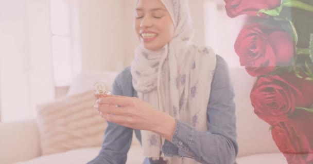 Animace Rudých Růží Nad Biracial Žena Hidžábu Úsměvem Pomocí Parfému — Stock video