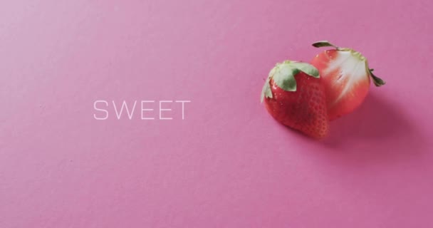 ピンクの背景にイチゴを半分にした甘いテキストのアニメーション フルーツ 健康的な食事 ビーガン新鮮な食品コンセプトデジタル生成ビデオ — ストック動画
