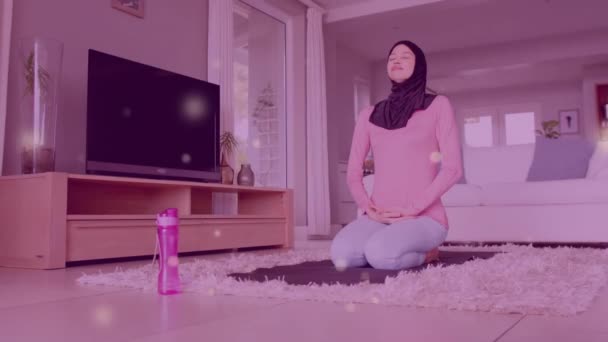 Animering Ljusfläckar Över Biracial Kvinna Hijab Praktiserar Yoga Livsstil Hushållsliv — Stockvideo