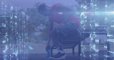 Bilgisayar sunucularının protez bacağı dışarıda dinlenen erkek atlet hakkında veri işleme görüntüsü.