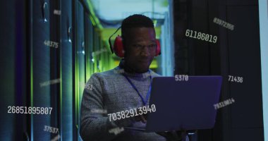 Afro-Amerikan erkek, it mühendisi ve bilgisayar sunucuları üzerinde veri işleme görüntüsü. 