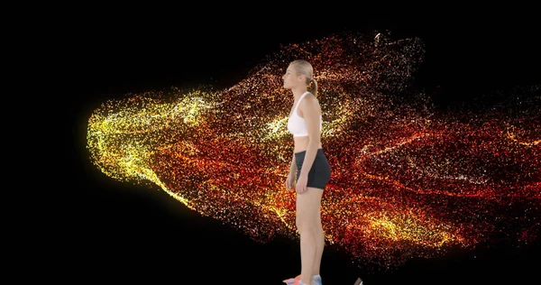 Image of glowing red particles and female runner getting onto starting blocks. sport and competition concept, digitally generated image.
