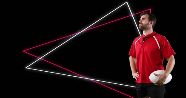 Image of red and white neon triangles and caucasian male rugby player holding ball. sport, competition and technology concept, digitally generated image.