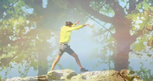 Człowiek Skacze Górskich Skałach Podnosi Ręce Triumfie Drzewa Pierwszym Planie — Zdjęcie stockowe