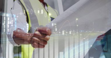 Asyalı mimar bina planını grafiklerle inceliyor.