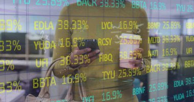 Akıllı telefon kullanan çift ırklı iş kadınının veri işleme görüntüsü. 