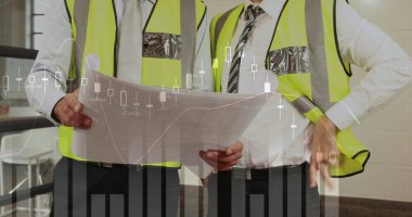 İki erkek mimar planlarını grafiklerle tartışıyor.