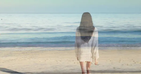 女性はビーチに立って波を眺める — ストック写真