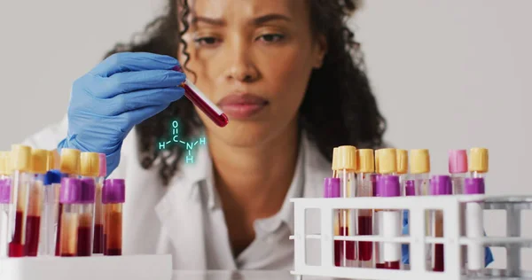 Image of chemical structures over biracial female doctor with test tubes. Global medicine and digital interface concept digitally generated image.