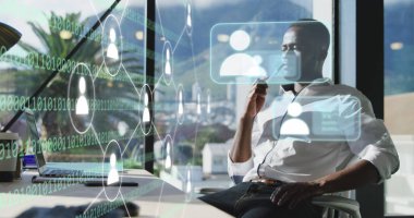 Afro-Amerikan iş adamının ofisinde çalışan ikonlar ve veri işleme resimleri. Dijital arayüz, bulut hesaplama ve veri işleme kavramı dijital olarak oluşturuldu.