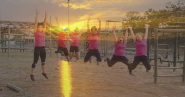 Engelli parkurda atlayan çeşitli kadınlar üzerinde günbatımının görüntüsü. Küresel spor, sağlık, fitness ve dijital arayüz kavramı dijital olarak oluşturulmuş görüntü.