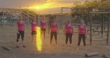 Engelli parkurda atlayan çeşitli kadınlar üzerinde günbatımının görüntüsü. Küresel spor, sağlık, fitness ve dijital arayüz kavramı dijital olarak oluşturulmuş görüntü.