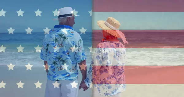 夏のビーチで多様なシニアカップル以上のアメリカの国旗のイメージ アメリカの多様性 愛国心をデジタルで生み出したイメージ — ストック写真