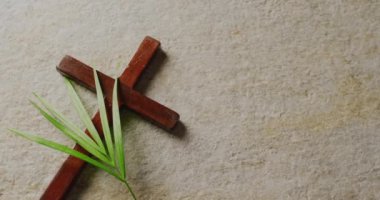Kutsal Cumartesi metninin haç üzerinde animasyonu ve gri arka planda avuç içi. Paskalya, gelenek ve kutlama konsepti dijital olarak oluşturuldu.