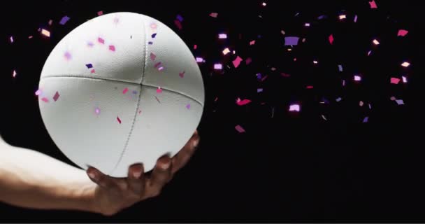 用高加索人的手握住的白色橄榄球球在黑色背景上动画 橄榄球 竞赛和庆祝概念数码视频 — 图库视频影像