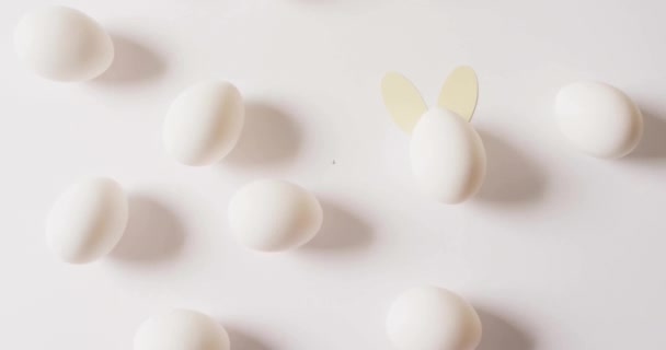白い背景に白い卵の上に幸せなイースターテキストのアニメーション イースター お祝いのコンセプトデジタル生成ビデオ — ストック動画