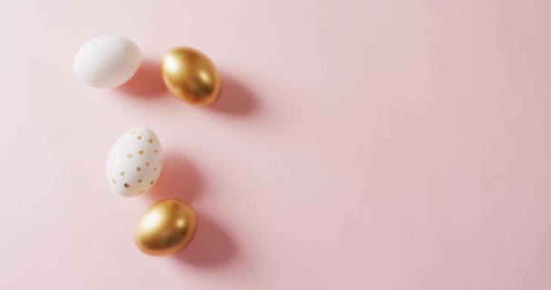 ピンクの背景に白と金の卵の上に幸せなイースターテキストのアニメーション イースター お祝いのコンセプトデジタル生成ビデオ — ストック動画