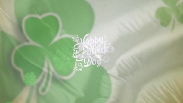 シャムロックとハッピー スタット パトリックの日々のテキストをアイルランドの国旗の上に写した セントパトリックの日とお祝いのコンセプトデジタル生成ビデオ — ストック動画