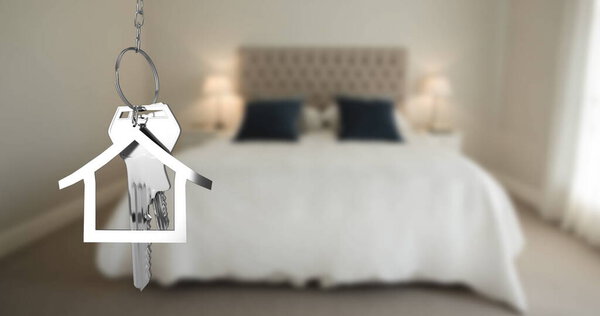 Image of silver house keys and house shaped key fob hanging over an out of focus bedroom 4k