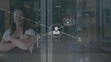 Çift ırklı kadın tezgahtar yerine simgelerle bağlantı ağının animasyonu. Küresel finans, iş, bağlantılar, hesaplama ve veri işleme kavramı dijital olarak oluşturulmuş video.