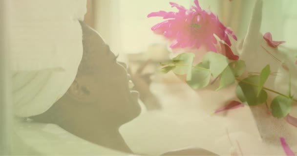 Animación Flores Rosadas Sobre Feliz Mujer Afroamericana Relajándose Bañera Naturaleza — Vídeo de stock