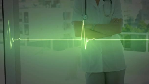 Hastanedeki Gülümseyen Beyaz Kadın Doktor Üzerinde Yeşil Kalp Atışı Monitörü — Stok video