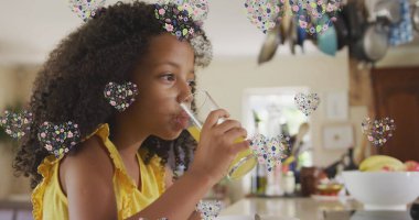 Evde meyve suyu içen Afrikalı Amerikalı kız yerine çiçek kalplerinin resmi. aile hayatı, ev ve çocukluk kavramı dijital olarak oluşturulmuş imaj.