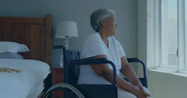 Starsza Birasowa Kobieta Siedzi Wózku Inwalidzkim Domu Patrząc Zewnątrz Wydaje — Zdjęcie stockowe