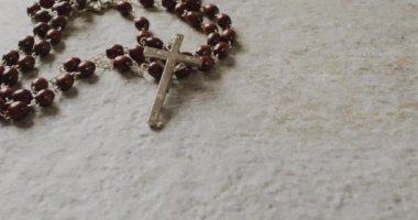 Kutsal Perşembe metninin gri arka planda Hristiyan tespihi üzerine animasyonu. Paskalya, din, Hıristiyanlık, gelenek ve kutlama konsepti dijital olarak oluşturulmuş video.