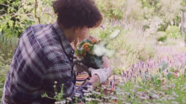 Neşeli bahçeye çiçek eken mutlu çiftin üzerindeki bulut evi animasyonu. Çift, bahçıvanlık, doğa, yaz, birliktelik, aşk ve romantizm, dijital olarak üretilen video.