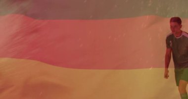 Kafkasyalı erkek futbolcunun topa vurması üzerine Alman bayrağının animasyonu. Spor, rekabet ve aktif yaşam tarzı konsepti dijital olarak oluşturulmuş video.