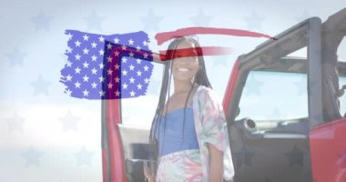 Amerika bayrağının animasyonu mutlu Afro-Amerikan kadınının plajda arabasıyla çekilmesi üzerine. Amerikan vatanseverliği, çeşitlilik ve tatil konsepti dijital olarak oluşturulmuş video.