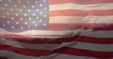 Amerika bayrağının yaz aylarında gün batımında deniz ve plajda canlandırılması. Amerikan vatanseverliği, çeşitlilik ve tatil konsepti dijital olarak oluşturulmuş video.