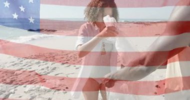 Amerika bayrağının yaz aylarında kumsalda geri dönüşümlü mutlu arkadaşlara göre canlandırılması. Amerikan vatanseverliği, çeşitlilik ve tatil konsepti dijital olarak oluşturulmuş video.