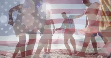 ABD bayrağı animasyonu ve kumsalda futbol oynayan çeşitli arkadaşların üzerindeki ışık izleri. Vatanseverlik ve kutlama konsepti dijital olarak oluşturulmuş video.