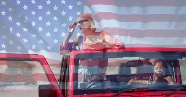 Animacja Flagi Usa Nad Afrykańskimi Amerykańskimi Kaukaskimi Przyjaciółkami Siedzącymi Samochodzie — Wideo stockowe