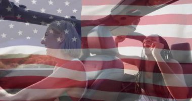 Amerika bayrağının yaz aylarında sahilden kumsala gezen mutlu kadınlar üzerindeki animasyonu. Amerikan vatanseverliği, çeşitlilik ve tatil konsepti dijital olarak oluşturulmuş video.
