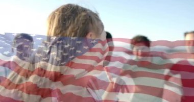 Amerika bayrağının yaz aylarında sahildeki çeşitli mutlu arkadaşlara karşı animasyonu. Amerikan vatanseverliği, çeşitlilik ve tatil konsepti dijital olarak oluşturulmuş video.