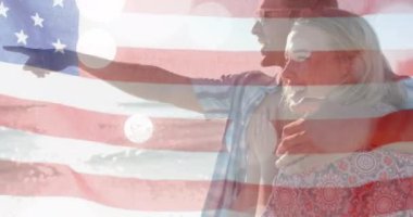 Yazın plajda mutlu beyaz bir çiftin bayrağının canlandırılması. Amerikan vatanseverliği, çeşitlilik ve tatil konsepti dijital olarak oluşturulmuş video.