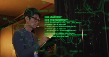 Sunucu odasında çalışan Asyalı erkek teknisyen üzerinde element şemaları ve veri işleme animasyonları. Bağlantı, araştırma, ai, dijital arayüz, veri ve iletişim, dijital olarak oluşturulmuş video.